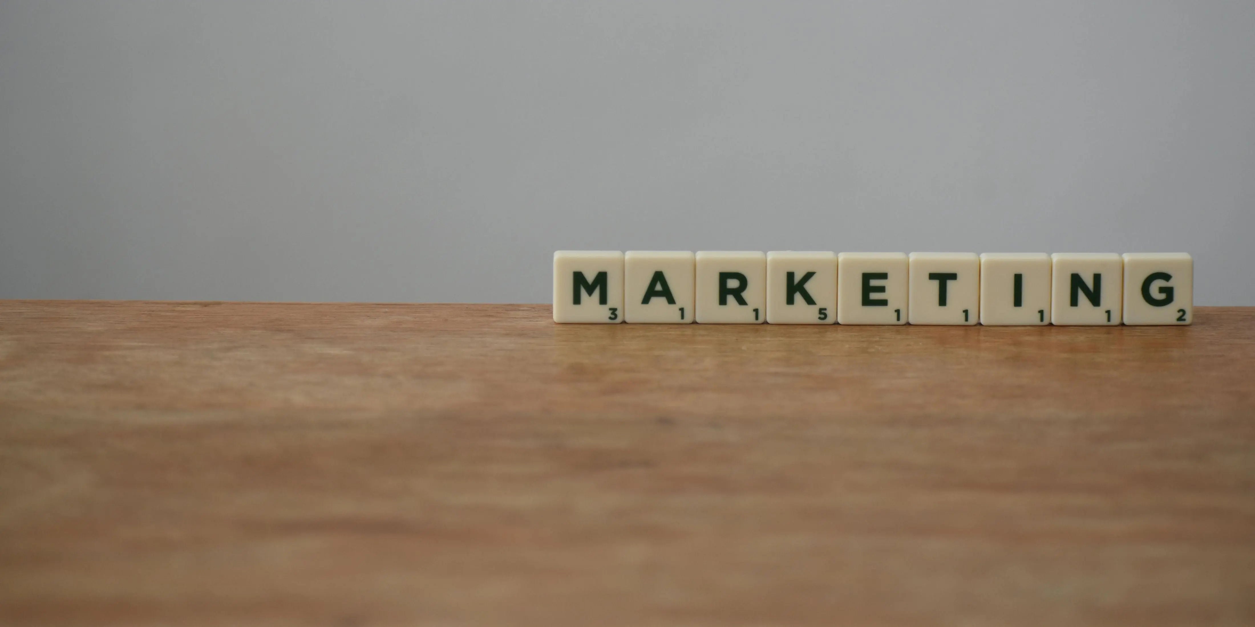 letters spelling out marketing are arranged on a wooden table