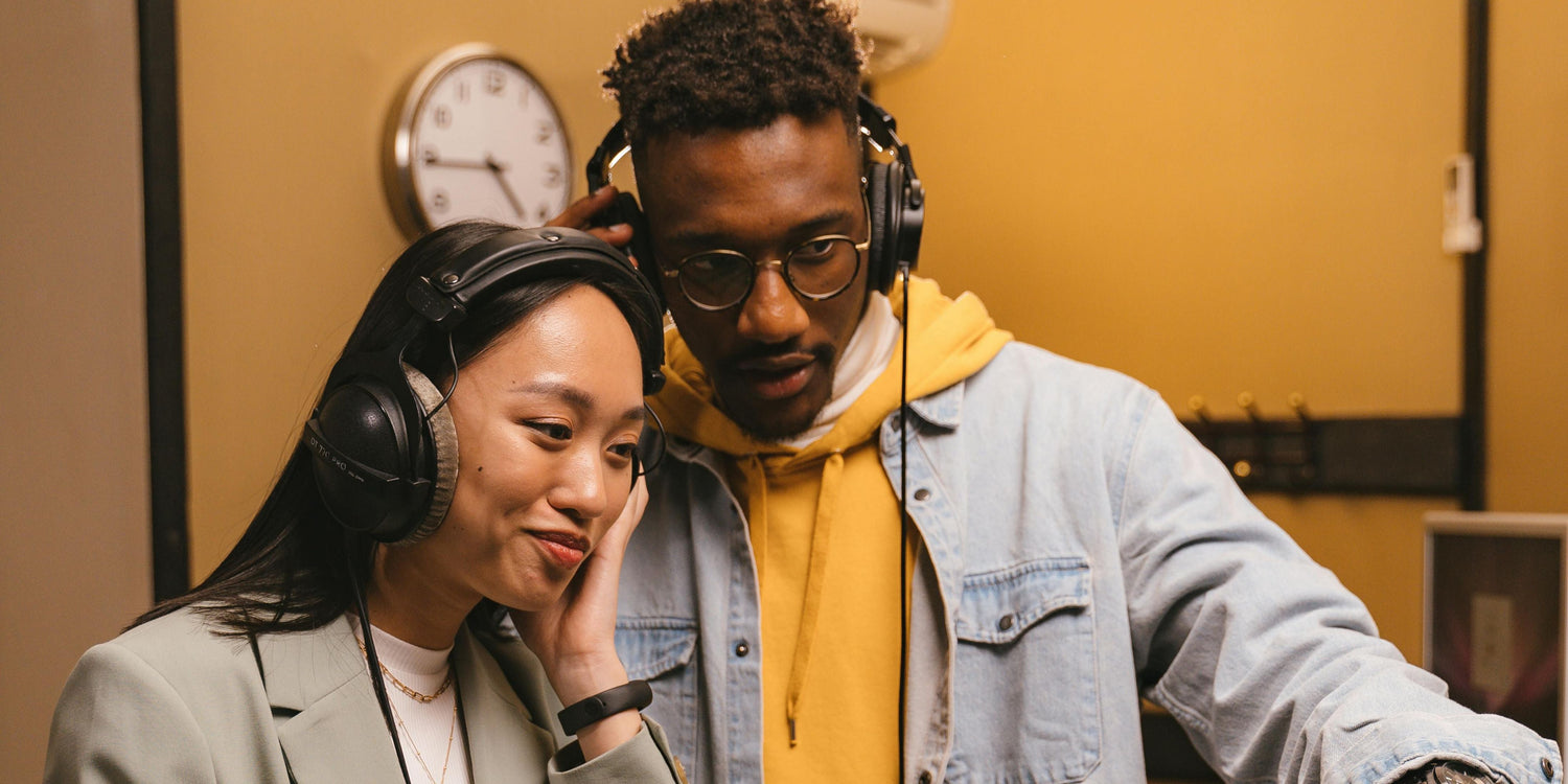 Man and woman wearing headphones in a music studio